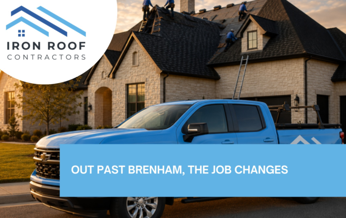 Blog hero image with the title of "Roof Replacement Brenham TX: What's Different Out Here" with a picture of Branded Iron Roof Co truck in the driveway while a crew works on the roof of a two-story home